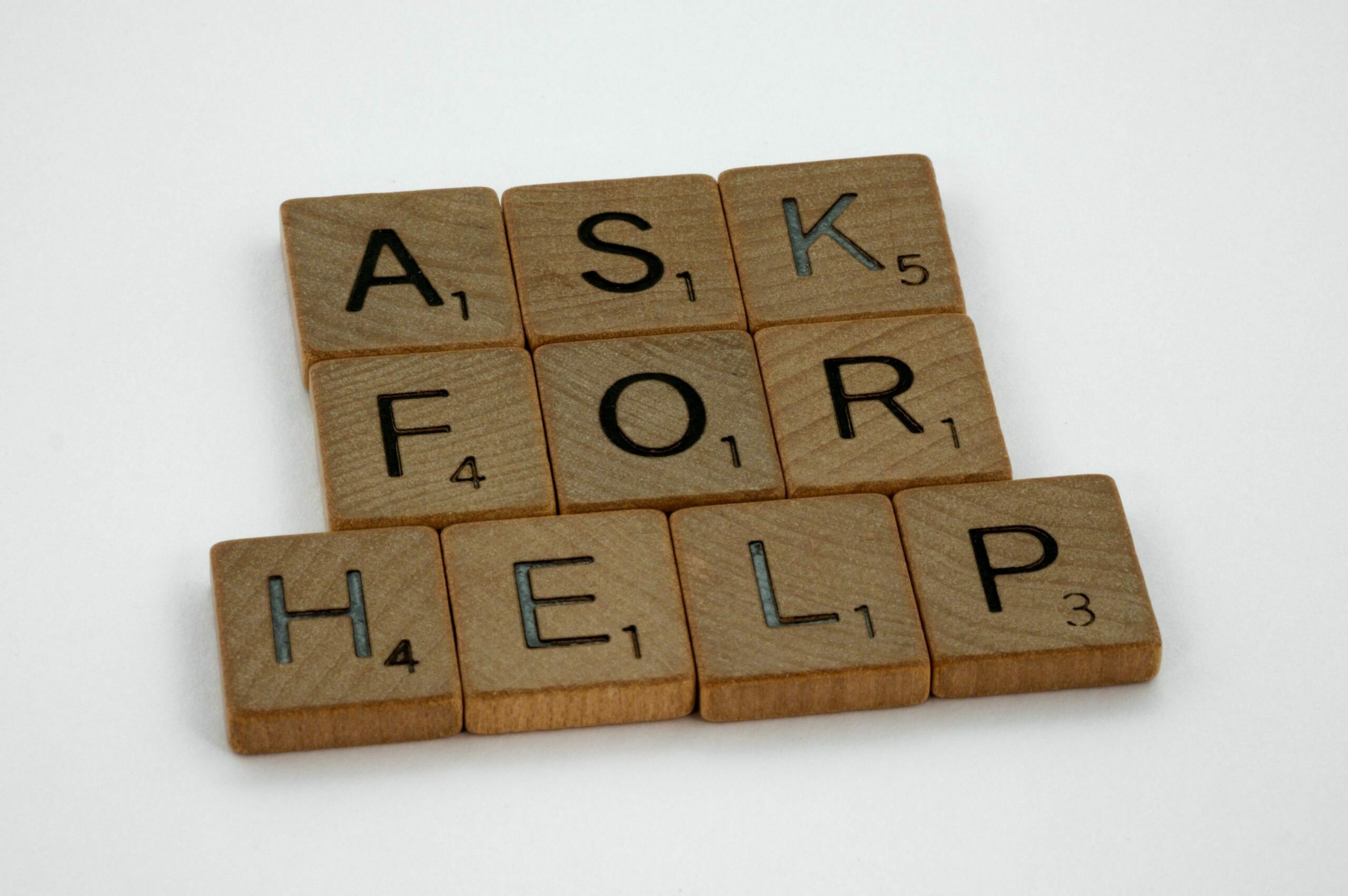 Scrabble tiles spell out "ask for help"