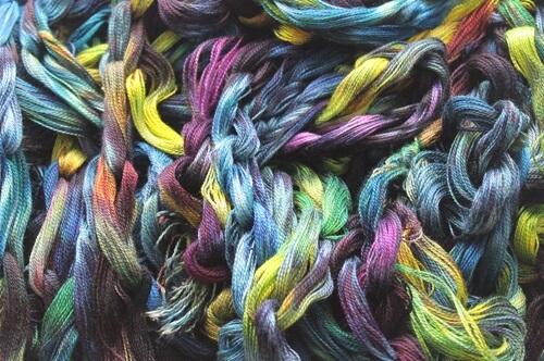 A close up image of a pile of warp chains. The chains have many colours that are randomly placed.