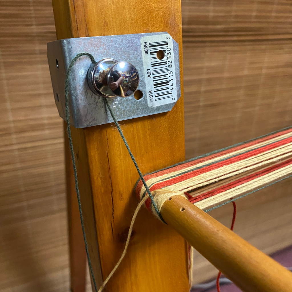 Photo of magnet attached to warping board to hold yarns in waiting.